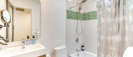 A modern bathroom with a shower, toilet, and sink.