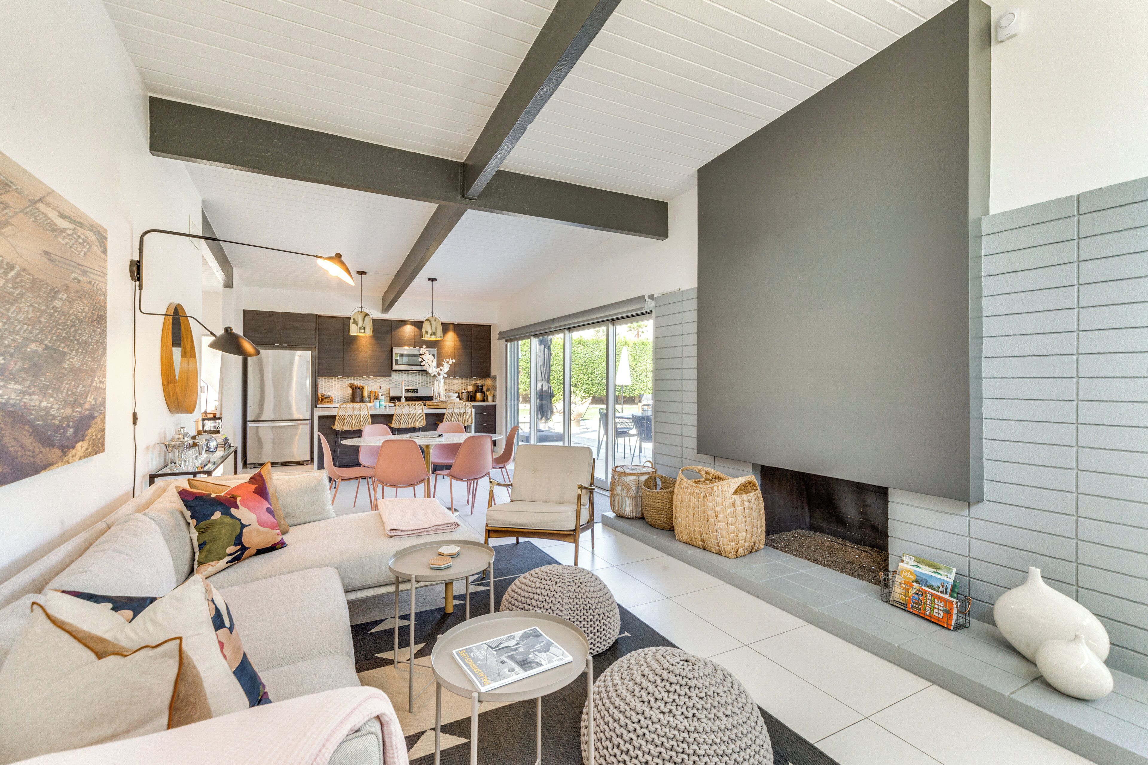 Ein modernes Wohnzimmer mit Kamin, Sitzecke und einer Küche im Hintergrund.
