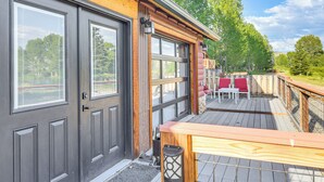 Et moderne hus med terrasse, garage og en lukket have med bord og stole.