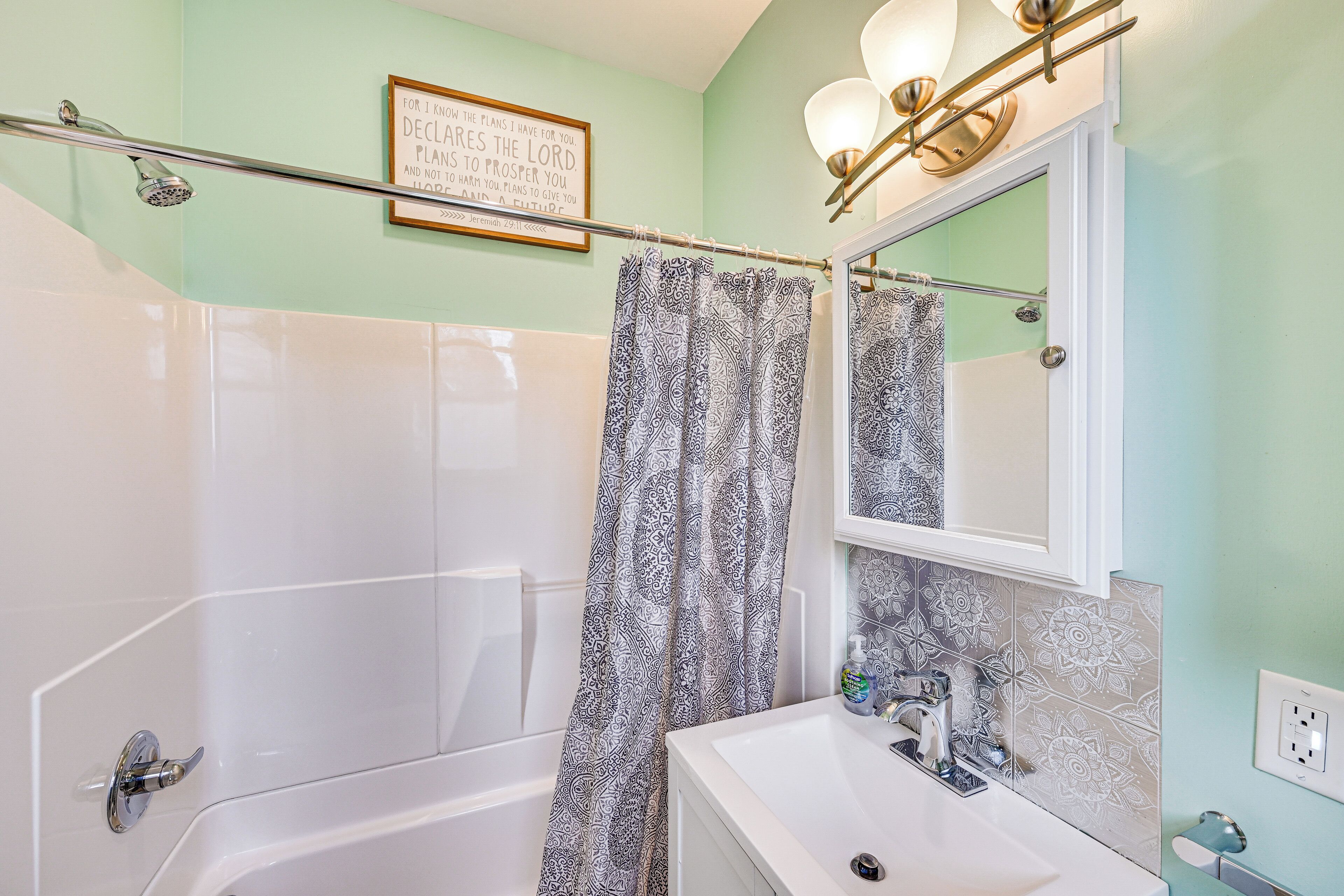 Une salle de bain avec une douche, un lavabo et un miroir.