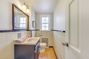 A compact bathroom with a sink, toilet, and a window. - Historic Manor 3 Mi to Shawnee Mtn! Pet Friendly (East Stroudsburg)