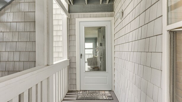 A narrow, white-paneled hallway with a welcome mat at the entrance. - Family-friendly Fort Walton Beach Condo w/ Views (Fort Walton Beach)