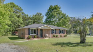 A single-story brick house with a front porch, a small lawn, and a palm tree. - 11 Mi to Beaches: Peaceful Foley Home w/ Yard (Foley)