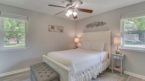 A bedroom with a bed, a ceiling fan, a nightstand, a lamp, and a window. - 11 Mi to Beaches: Peaceful Foley Home w/ Yard (Foley)