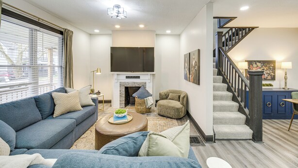 A modern living room with a sofa, coffee table, and a fireplace. - 4 Mi to Dtwn: Modern Retreat w/ Yard in Cleveland (Cleveland)