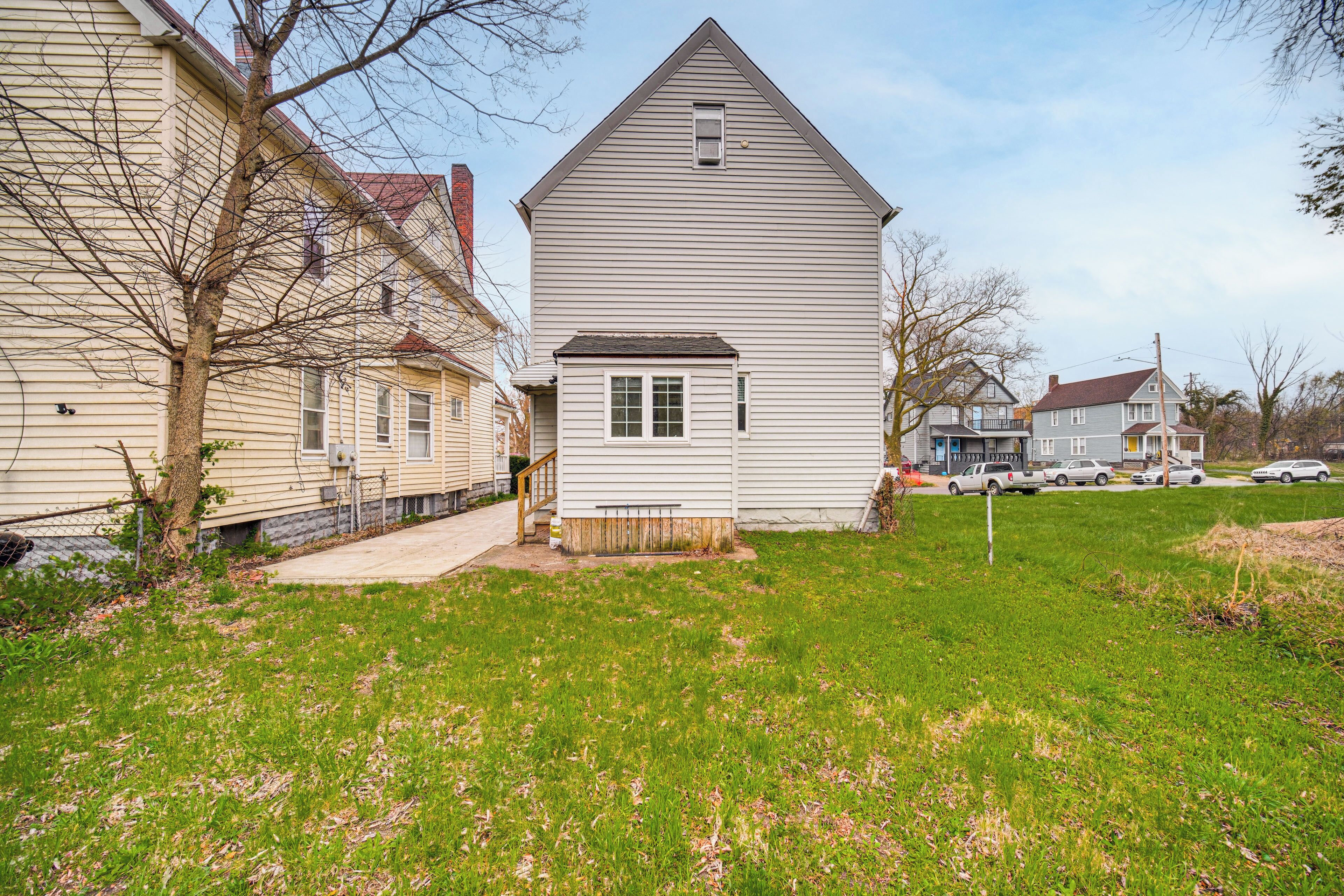 A residential area with houses, a grassy yard, and a driveway.