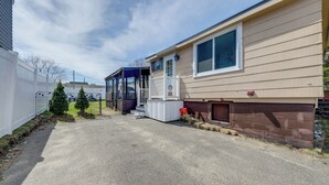 Ein Bungalow mit überdachter Veranda und einem kleinen Anbau als Garage.