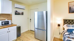 A compact kitchen with a microwave, a stainless steel refrigerator, and a white cabinet. - 2 Mi to Feather River: Outdoor Escape in Oroville! (Oroville)