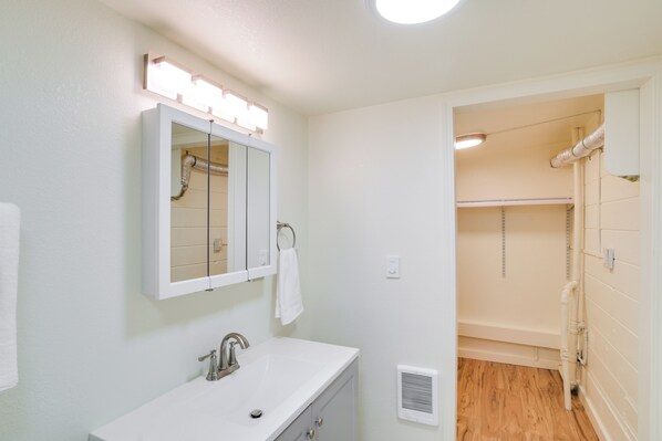 A bathroom with a white sink, mirror, and lighted vanity. - 2 Mi to Feather River: Outdoor Escape in Oroville! (Oroville)