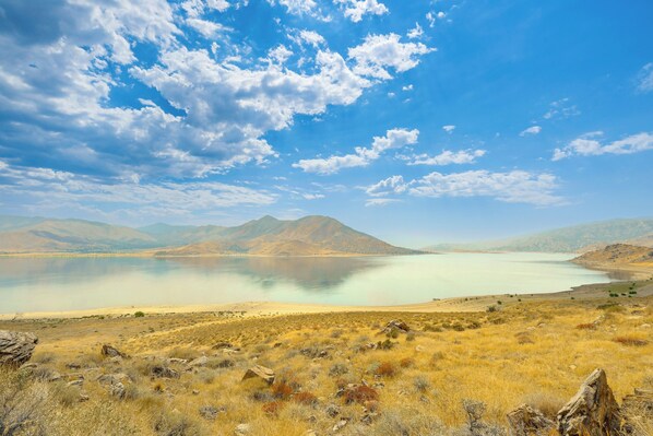 A panoramic view of a lake surrounded by mountains and dry grassland. - Walk to Riverfront Beach: Kernville Escape (Kernville)