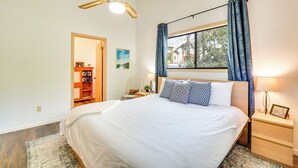A bedroom with a large bed, a ceiling fan, a window with curtains, a bedside table with a lamp, and a nightstand with a picture frame. - Dock on Hiwassee Lake! Family Murphy Retreat (Murphy)