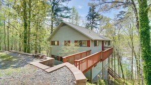 A cabin with a deck, surrounded by trees and a body of water. - Dock on Hiwassee Lake! Family Murphy Retreat (Murphy)