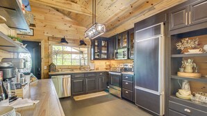 A modern kitchen with dark cabinets, stainless steel appliances, and a wooden ceiling. - Deck & Yard: 'margy's Farmhouse' in Jasper (Jasper)