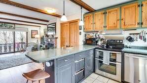 Una cucina con mobili in legno, un piano di lavoro in granito, forno integrato e lavastoviglie in acciaio inossidabile.
