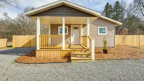 Une maison de plain-pied avec un porche abrité, une porte d’entrée et un petit jardin.