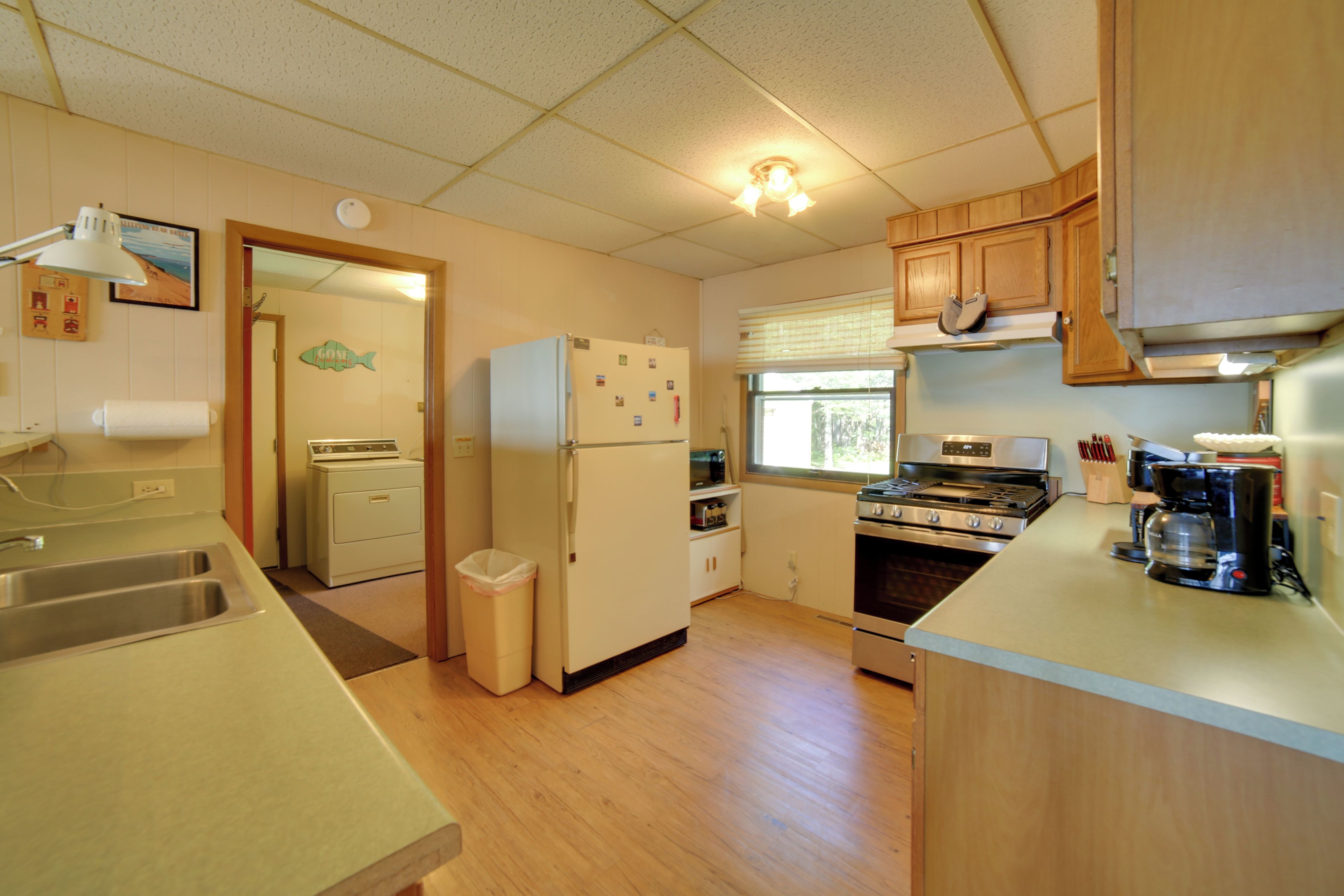 A compact kitchen with a refrigerator, stove, microwave, and a coffee maker.