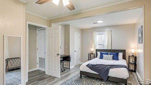 A bedroom with a bed, bedside tables, a desk, a chair, and a ceiling fan. - < 5 Mi to Dtwn Walterboro: Grill, Game & More! (Walterboro)