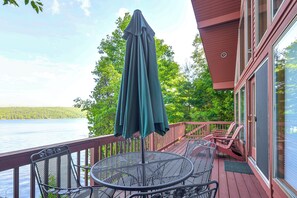 A wooden deck with a table and chairs, overlooking a lake. - 'sweet Serenity' Schroon Lake Family Retreat! (Schroon Lake)