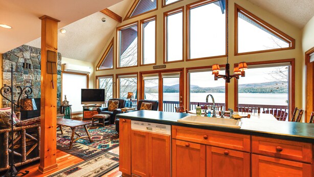 A spacious kitchen with large windows, a stone wall, and a view of a lake. - 'sweet Serenity' Schroon Lake Family Retreat! (Schroon Lake)