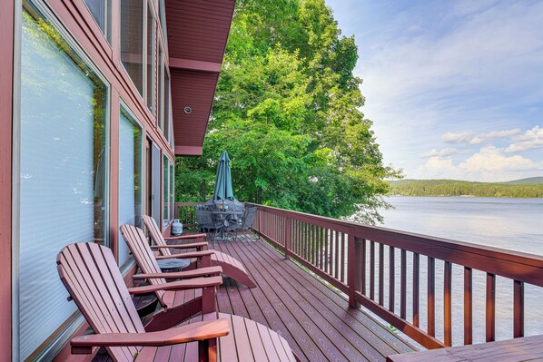 A wooden deck with Adirondack chairs and a grill, overlooking a lake with trees and hills in the background. - 'sweet Serenity' Schroon Lake Family Retreat! (Schroon Lake)