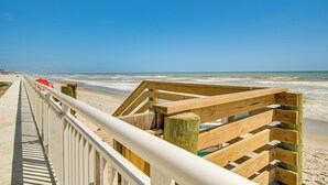 A wooden boardwalk leading to the beach with a clear view of the ocean. - Steps to Ocean: Satellite Beach Condo w/ Balcony (Satellite Beach)