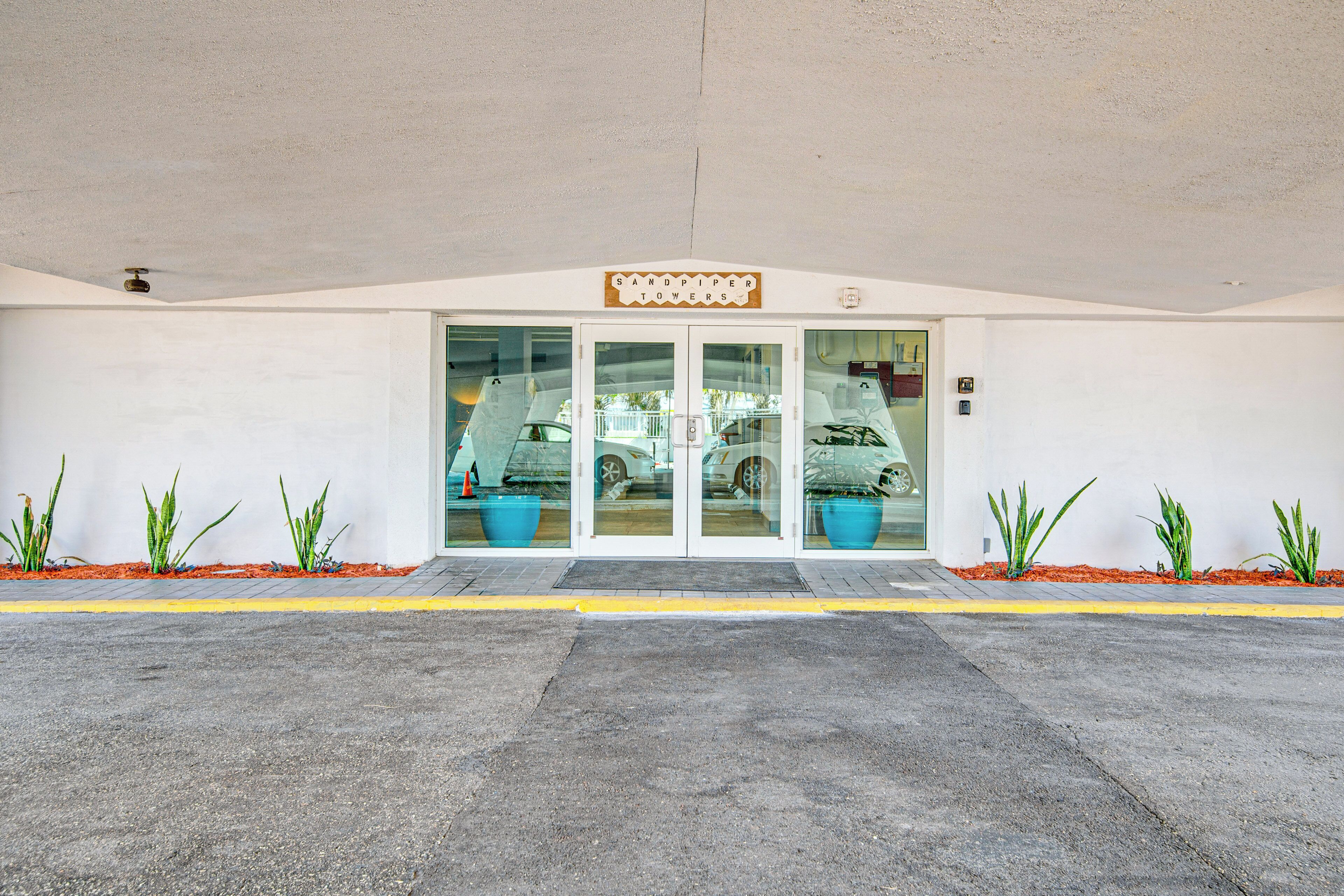 A building entrance with a sign reading "Sandpiper Towers."