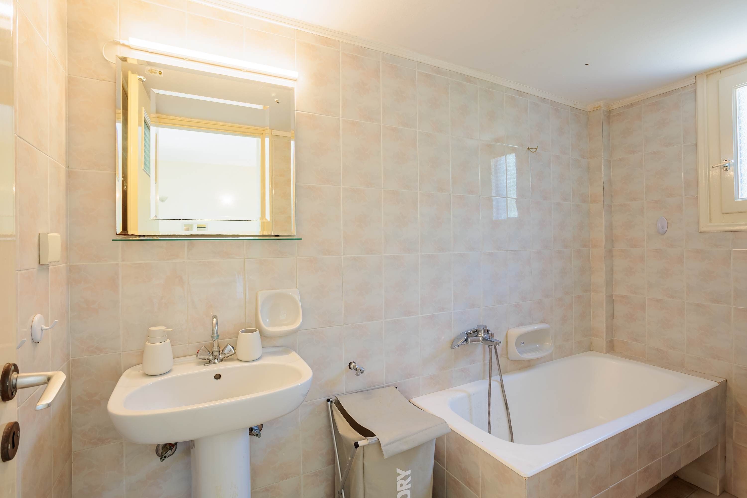 Ein modernes Badezimmer mit Waschbecken, Spiegel und Badewanne.
