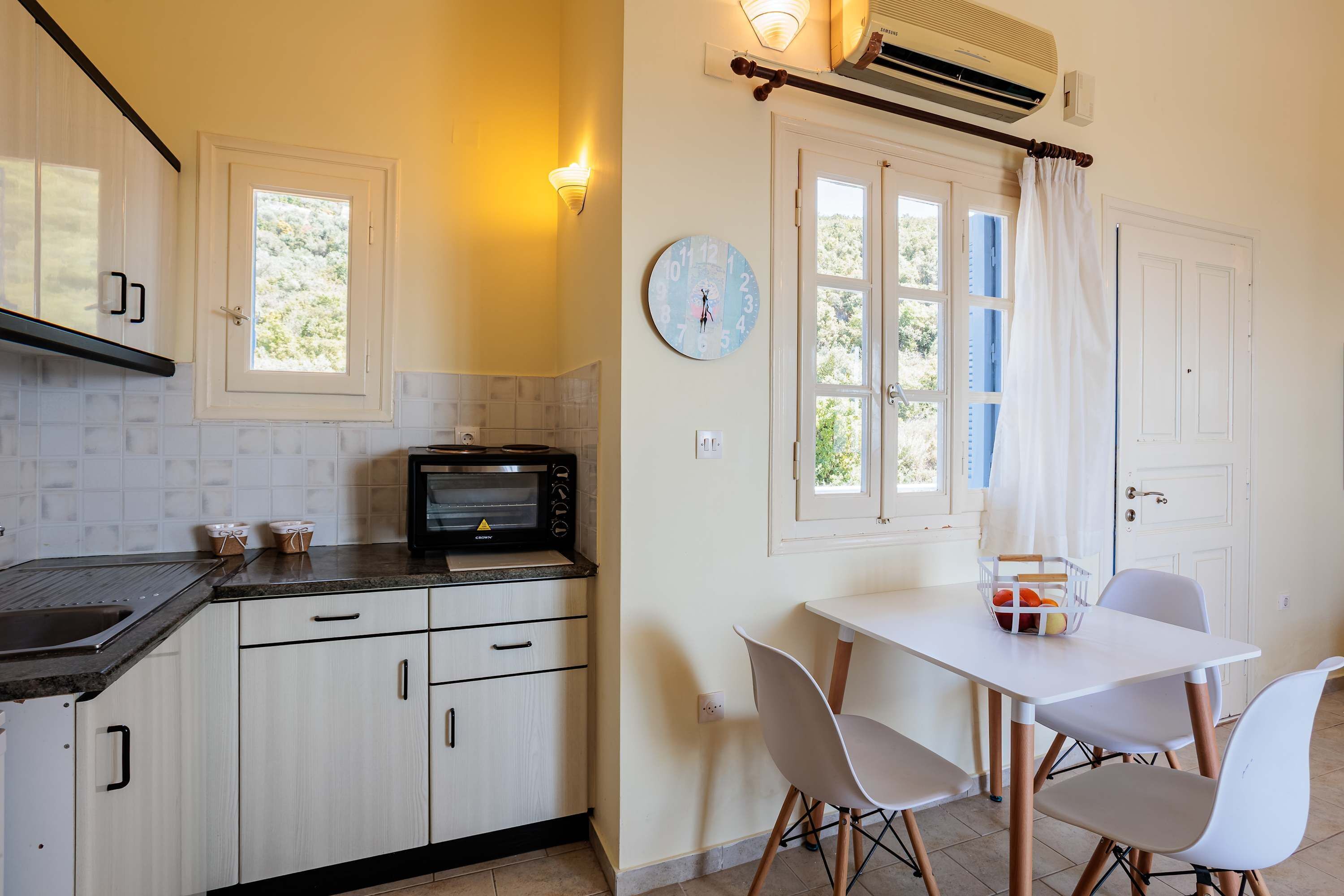 A kitchen with a microwave, cabinets, and a dining table with chairs.