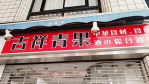 Ein Schaufenster mit einem roten Schild, auf dem "Gokyo Kyojo" steht, und einer blauen Markise darüber.