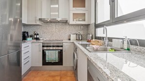 A modern kitchen with stainless steel appliances, granite countertops, and a window providing natural light. - RDR487 - Modern Duplex Penthouse in gated complex (Estepona)