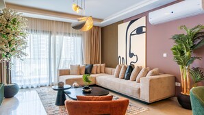 Ein modernes Wohnzimmer mit einem beigefarbenen Sofa, einem Couchtisch und einem großen abstrakten Gemälde an der Wand.