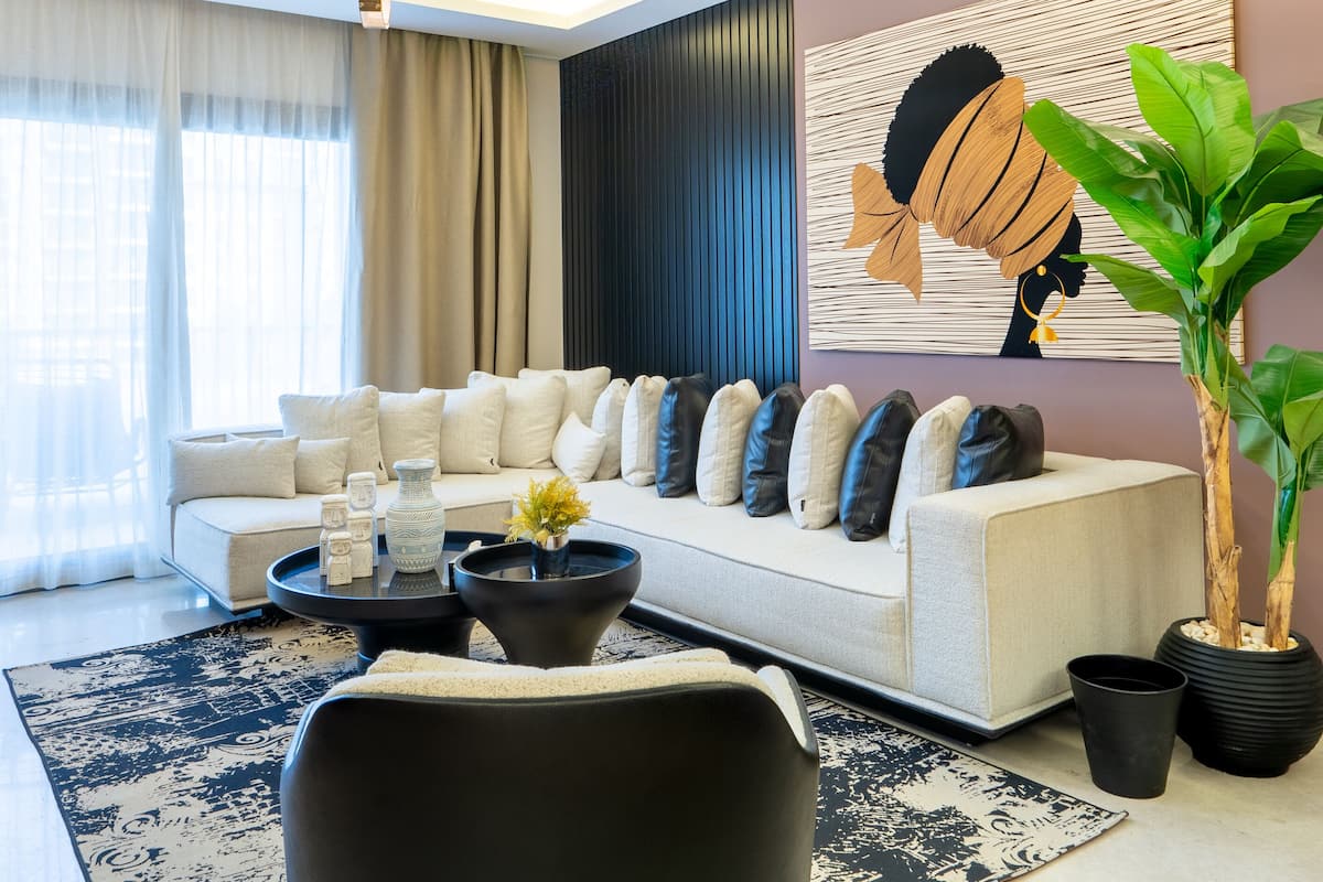 A modern living room with a sofa, coffee table, and a large abstract painting on the wall.