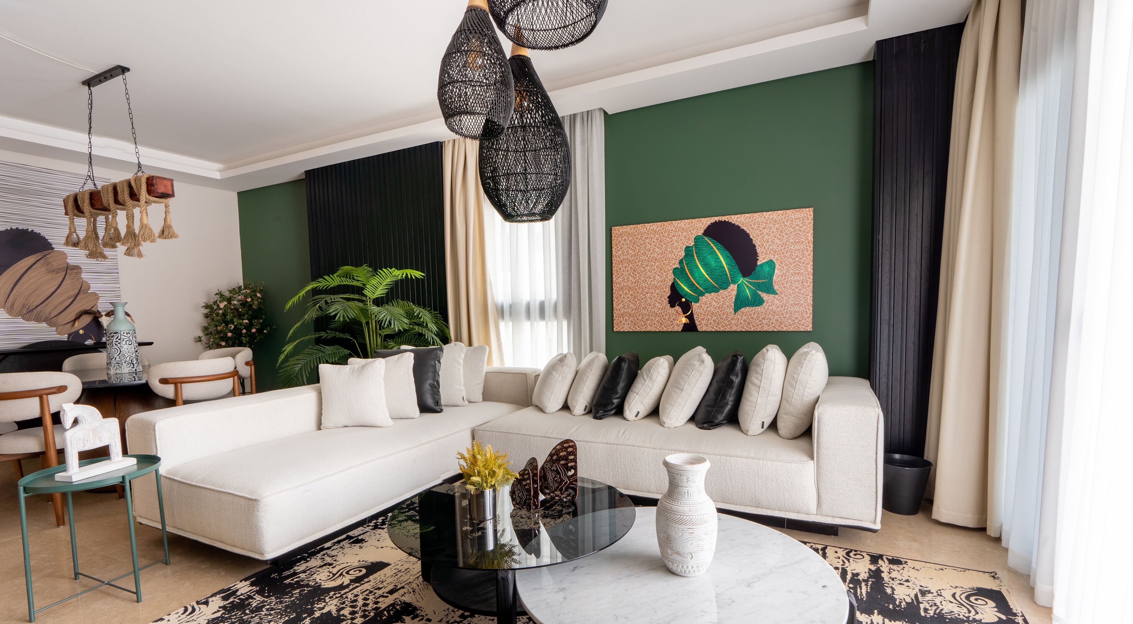 Een moderne woonkamer met een witte bank, een glazen salontafel en een groene accentmuur.