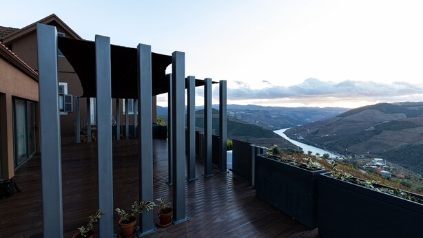 A balcony with a wooden floor, potted plants, and a view of a valley and river. - Dorigem Rooms (Room 2- Twin Room) (Casal de Loivos)