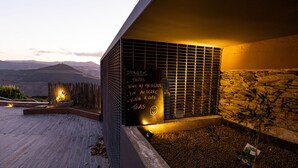 A modern building with a sloped roof, a stone wall, and a wooden fence. - Dorigem Rooms (Room 2- Twin Room) (Casal de Loivos)