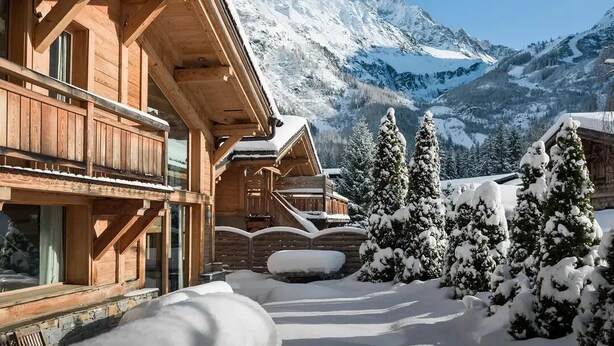 A wooden chalet with a balcony, surrounded by snow-covered trees and mountains in the background. - Les Rives d'Argentière (Chamonix-Mont-Blanc)