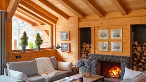 A cozy log cabin interior with a fireplace, wooden beams, and a comfortable seating area. - Les Rives d'Argentière (Chamonix-Mont-Blanc)