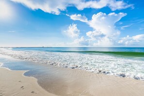 Uma praia com céu limpo e ondas.