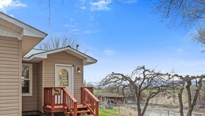 A house with a porch, a welcome sign, and a view of a river. - Pet Friendly Home with Fishing Access and Fire Pit (Kalispell)