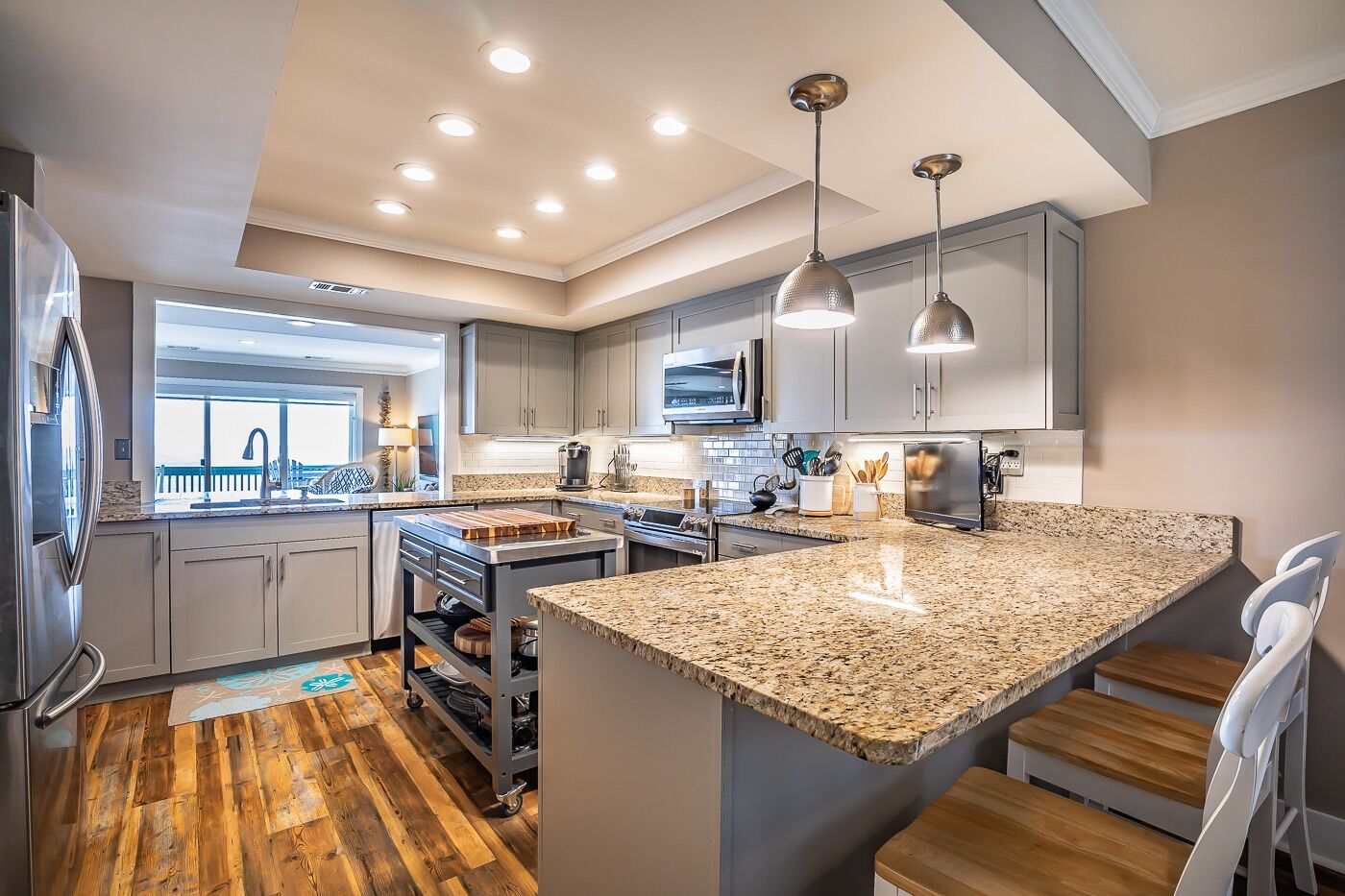 Una cocina moderna con encimeras de granito, electrodomésticos de acero inoxidable y una isla grande.