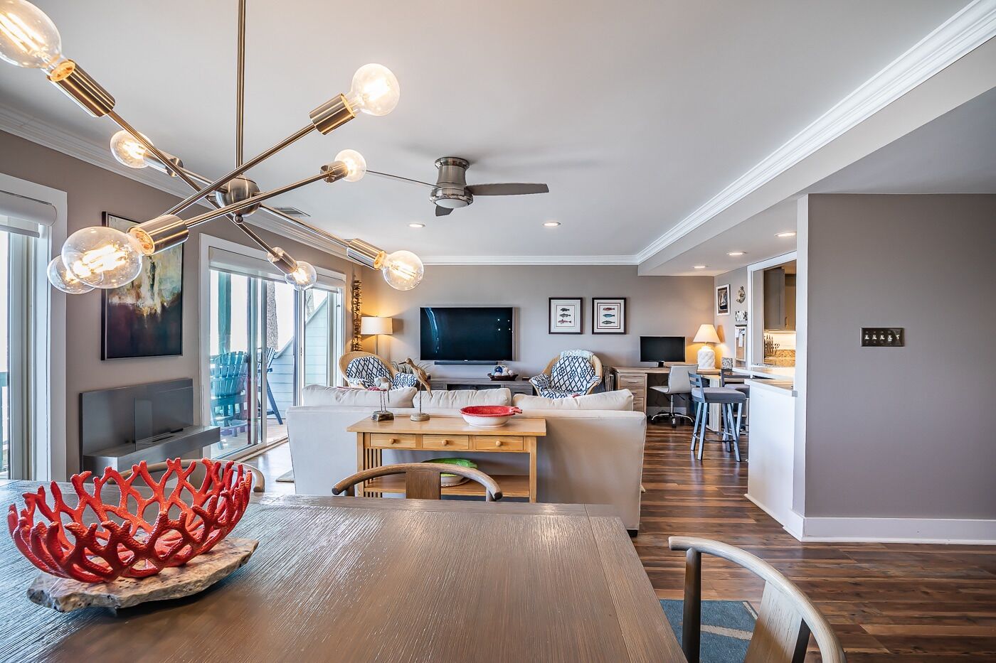 Una sala de estar moderna con comedor, cocina y ventilador de techo.