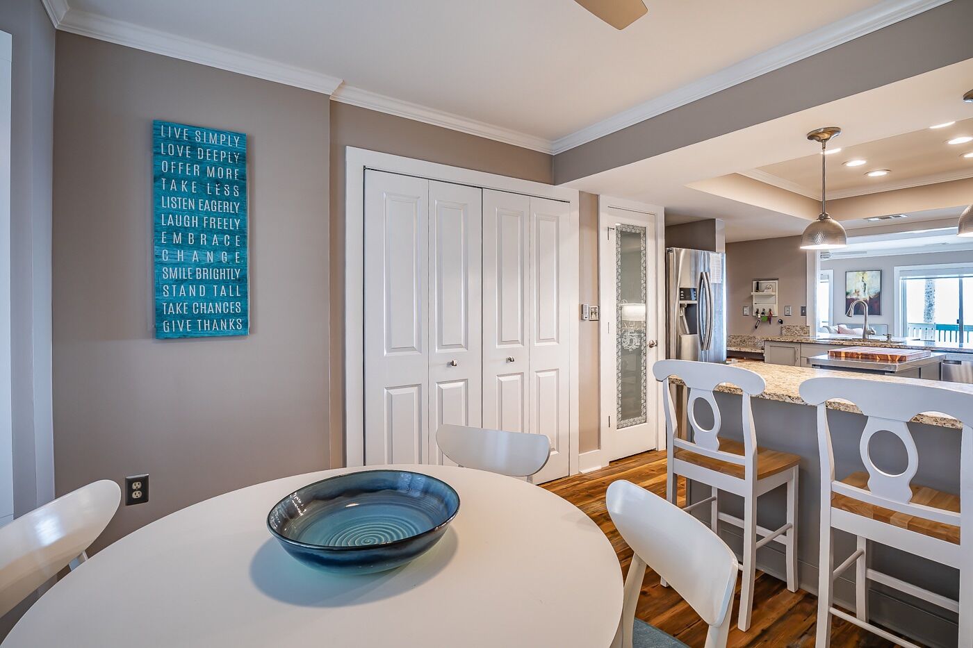 A modern kitchen with a white countertop, a built-in oven, and a stainless steel refrigerator.