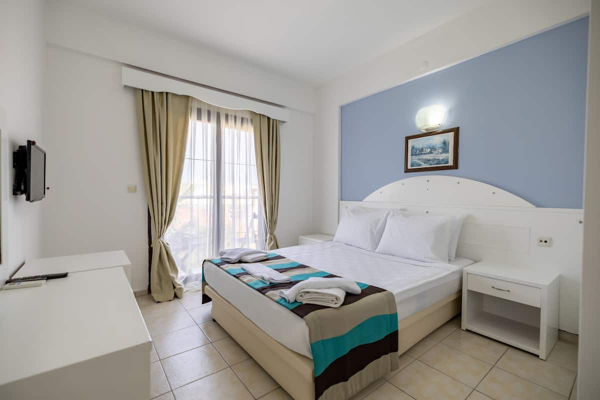 Ein Hotelzimmer mit Bett, Nachttisch und Schreibtisch.