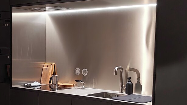 A modern kitchen with a built-in stove, a sink, and a faucet.