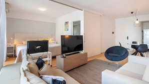 A modern hotel room with a bed, a TV, a sofa, and a dining area. - King Suite in Recoleta with Pool & Gym (Buenos Aires)