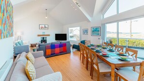 A spacious living area with a large dining table, a sofa set, and a television. - 4 Bed in Instow (oc-i31748) (Instow)