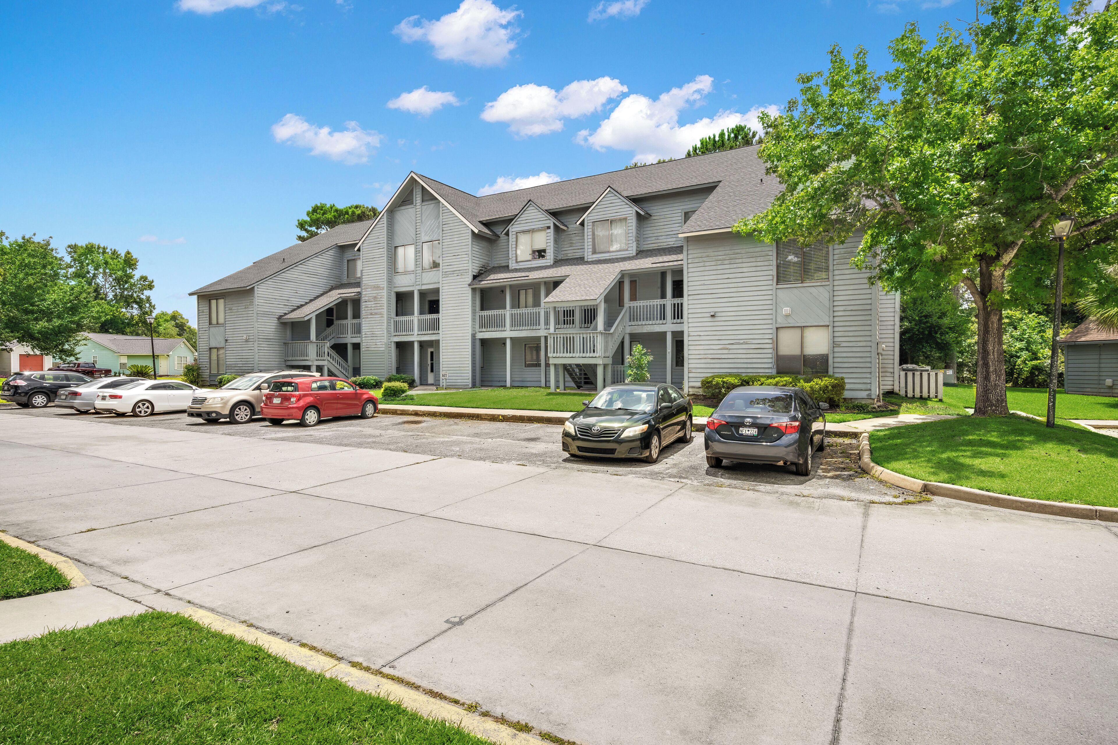 A multi-story apartment building with a parking lot.