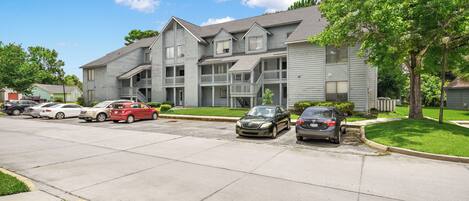 A multi-story apartment building with a parking lot.