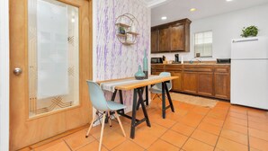 A compact kitchen with wooden cabinets, a white refrigerator, and a dining table with two chairs. - Your Perfect Private HideAway (Houston)