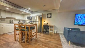Una cocina moderna con armarios de madera, un refrigerador de acero inoxidable y una mesa de comedor con sillas.